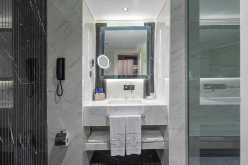 ein Bad mit einem Waschbecken und einem Spiegel in der Unterkunft Merit Park Hotel Casino & SPA in Kyrenia
