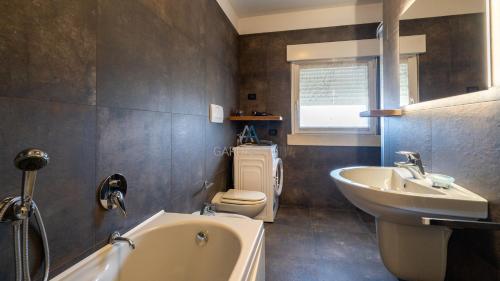 bagno con vasca, lavandino e servizi igienici di Palladium Apt -Attico Vista Lago in centro Colombare, Sirmione a Sirmione