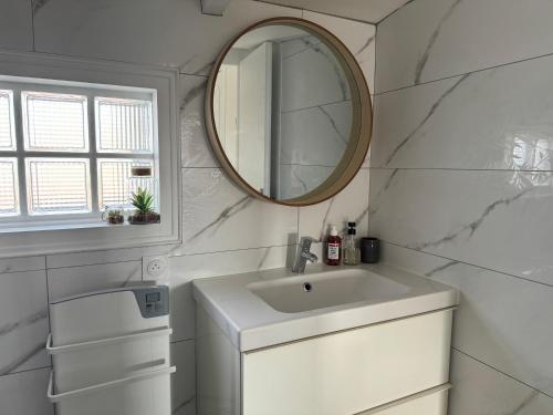 ein weißes Badezimmer mit einem Waschbecken und einem Spiegel in der Unterkunft ღ La Cabane Rochelaise • Vue sur le vieux-port in La Rochelle