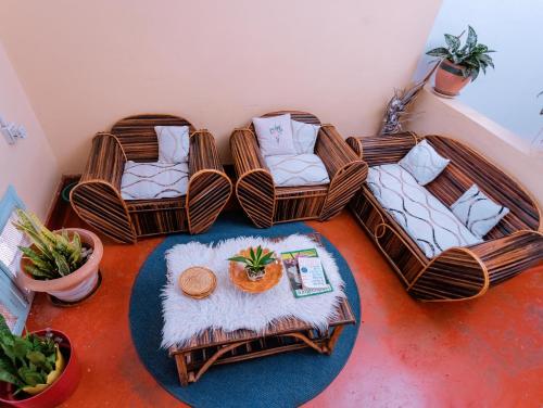 una habitación con 4 sillas de mimbre y una mesa en FARAJA HOMESTAY- Seamless Comfort in the Heart of the City - Free WiFi, Warm Hospitality, and Local Delights Await en Moshi