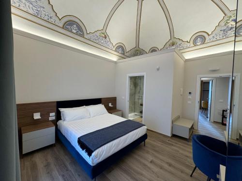 a bedroom with a large bed and a large ceiling at B&B Palazzo Croghan in Torre Maggiore