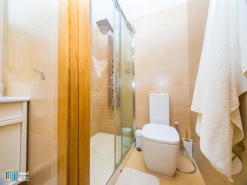 uma casa de banho com um WC e uma cabina de duche em vidro. em Apto Diana em Platja d'Aro