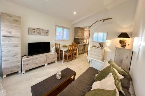 a living room with a couch and a table at Bastide du Levant - 50m plage - Rez de jardin in Sainte-Maxime