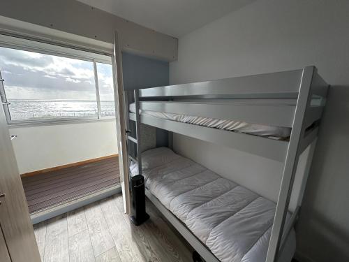 Cette chambre dispose de lits superposés et d'une fenêtre. dans l'établissement L'eden plage, à Saint-Hilaire-de-Riez