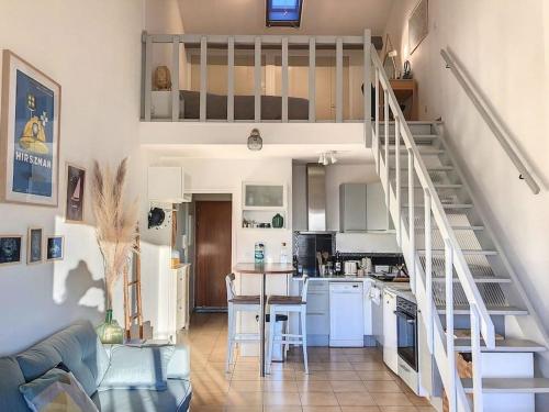Il comprend un salon et une cuisine avec un escalier en colimaçon. dans l'établissement Duplex Cosy à 4 min des plages, à Six-Fours-les-Plages