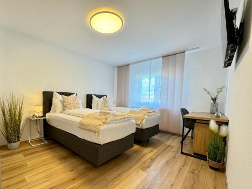 レーオンベルクにある3 Zimmer Apartment, 95 qm, max 5 Personen, Balkon, Garage, Internet 100 MBitのベッド2台とテーブルと机のある寝室