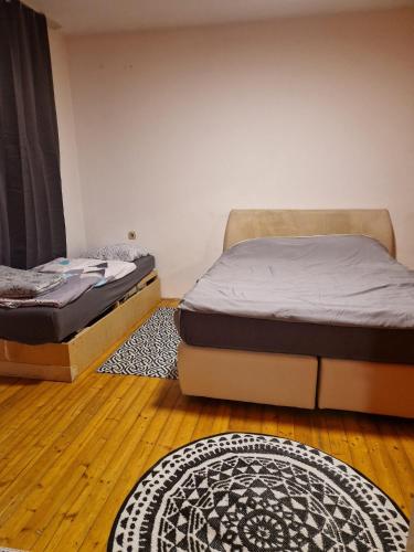 two beds in a room with wooden floors at Schick und Gemütlich in Ebenfurth