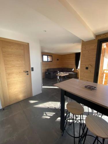 a room with a table and two stools and a door at Appartement bas de chalet in Font Romeu Odeillo Via