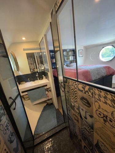 Cette chambre comprend un lit, un bureau et un miroir. dans l'établissement Dépaysement Art déco sur Seine à 2 pas de Paris, à Saint-Cloud