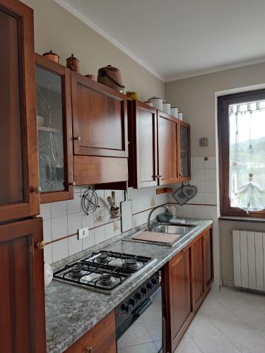 a kitchen with wooden cabinets and a stove top oven at Come a casa in Monsummano