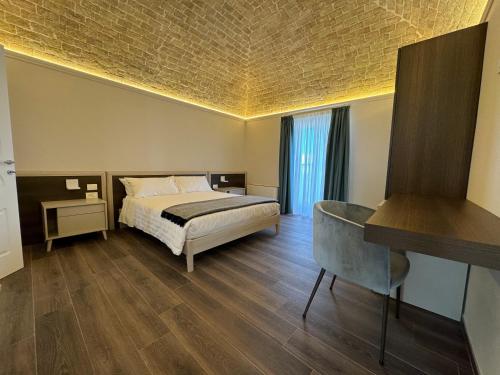Schlafzimmer mit einem Bett, einem Tisch und einem Schreibtisch in der Unterkunft B&B Palazzo Croghan in Torre Maggiore