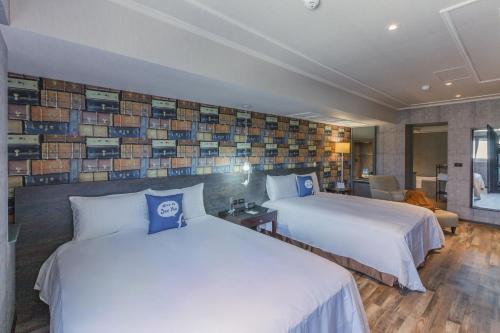 a hotel room with two beds and a wall of books at CU Hotel Kaohsiung in Kaohsiung