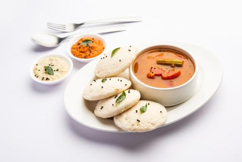 um prato de comida com uma tigela de sopa e biscoitos em Hotel Triton - Near US Embassy em Mumbai