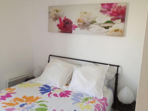 - un lit avec des oreillers blancs et une photo sur le mur dans l'établissement LOVELY APT BY BEACH WITH SEA VIEWS, à Antibes