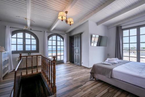 a bedroom with a bed and a staircase with windows at Selianitika Bay Γ2 Loft in Selianitika