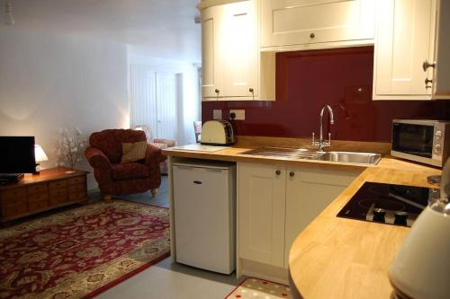 a kitchen with white cabinets and a counter top at The Post House (Centre of riverside village) in Stoke Gabriel