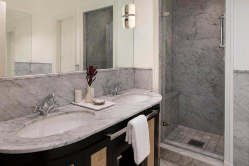 a bathroom with two sinks and a shower at Cape Grace, A Fairmont Managed Hotel in Cape Town