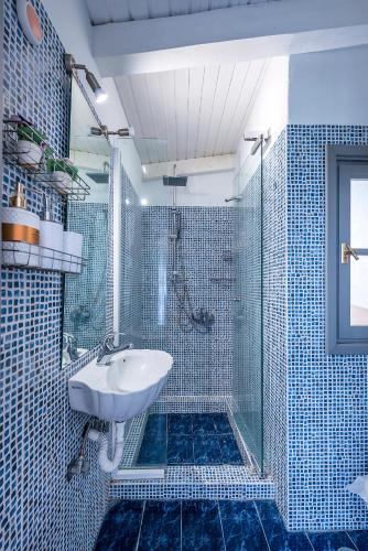 a blue tiled bathroom with a sink and a shower at Selianitika Bay Γ2 Loft in Selianitika