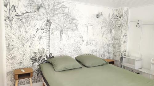 une chambre avec un lit avec un papier peint tropical dans l'établissement Maisonnette avec jardin - proche Paris - Disney, à Gagny
