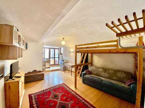 un soggiorno con letto a soppalco e divano di Monolocale accogliente a Bardonecchia