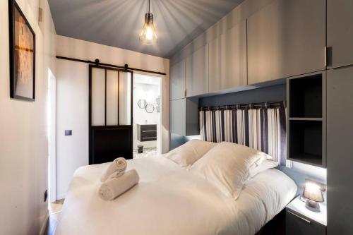 - une chambre avec un grand lit blanc et une serviette dans l'établissement Vieux Lyon avec vue sur la Saône AIL, à Lyon