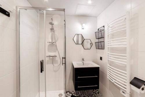 une salle de bain blanche avec une douche et un lavabo dans l'établissement Vieux Lyon avec vue sur la Saône AIL, à Lyon