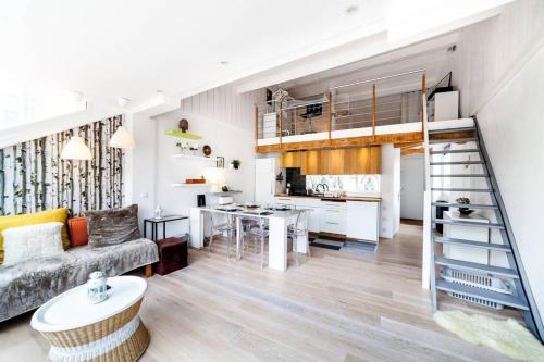 un salon avec un canapé et une cuisine dans l'établissement Panorama unique - duplex en hyper centre AIL, à Lyon