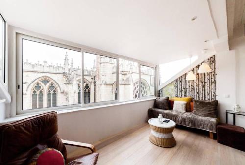 un salon avec un canapé et une grande fenêtre dans l'établissement Panorama unique - duplex en hyper centre AIL, à Lyon