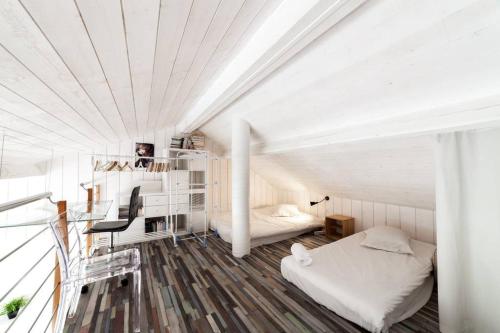 Cette chambre blanche comprend un lit et un bureau. dans l'établissement Panorama unique - duplex en hyper centre AIL, à Lyon
