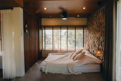 a bedroom with a large bed with a window at The CAMPIAN in Chiang Mai