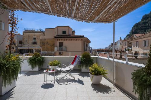 een balkon met een tafel en een stoel op een dak bij Rooftop 19_Amalfi Luxury Suite in Amalfi