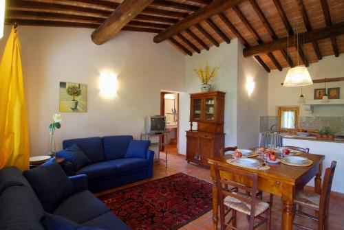 a living room with a blue couch and a table at Agriturismo Raccianello in San Gimignano