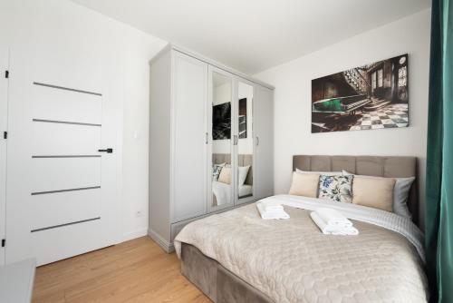 a bedroom with a bed and a dresser at Brzeziny Deluxe Apartment in Warsaw