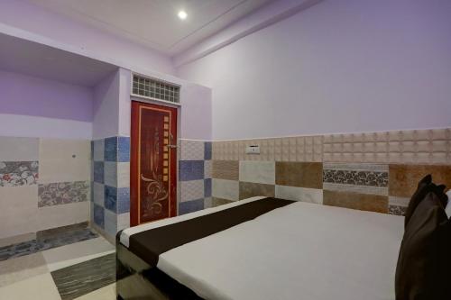 um quarto com uma cama e uma porta vermelha em OYO Mansi Hotel em Alīgarh