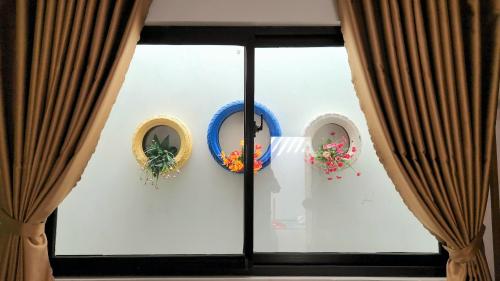 a window with three wreaths on a wall at HANID Hotel in Tuy Hoa