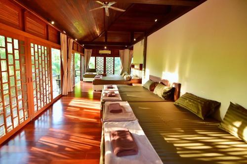 a living room with long beds in a room with windows at SS pool villa hills in Ban Tao Than