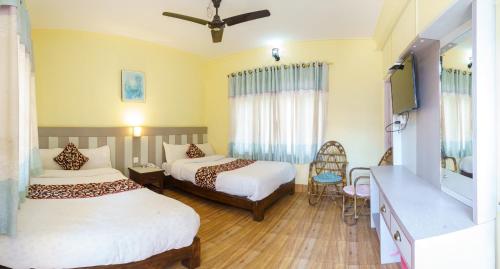 a hotel room with two beds and a tv at Hotel Angel in Pokhara