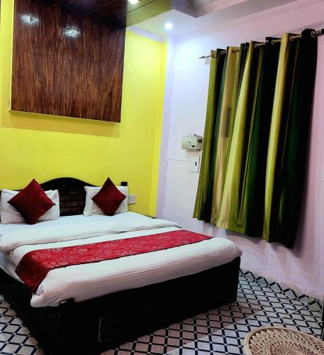 um quarto com uma cama com paredes amarelas e almofadas vermelhas em The Castle em Nova Deli