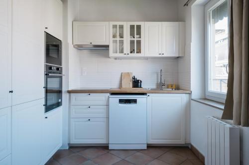 uma cozinha com armários brancos e uma máquina de lavar louça branca em The Célestins - center near Bellecour AIL em Lyon