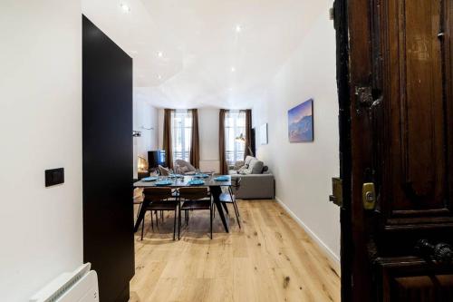 a dining room and living room with a table and chairs at Pur bonheur Hôtel de ville - clim et balnéo AIL in Lyon