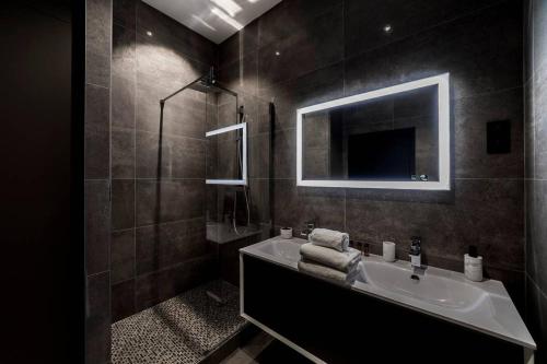 a bathroom with a sink and a mirror at Pur bonheur Hôtel de ville - clim et balnéo AIL in Lyon