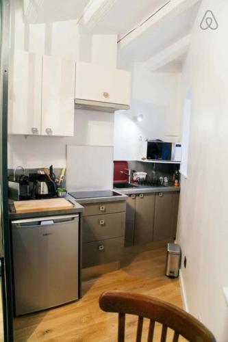 une cuisine avec des armoires blanches et un plancher en bois dans l'établissement Le Saint-Paul du Vieux-Lyon - parking inclus AIL, à Lyon