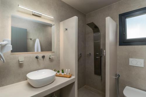 ein Bad mit einem Waschbecken und einer Dusche in der Unterkunft Afroessa Milos in Adamas
