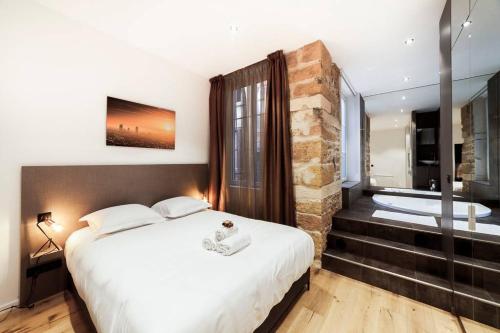 um quarto com uma cama grande e uma banheira em Pure happiness -AC and balneotherapy AIL em Lyon