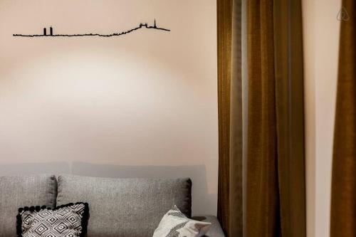 a living room with a couch and a chart on the wall at Pur bonheur Hôtel de ville - clim et balnéo AIL in Lyon