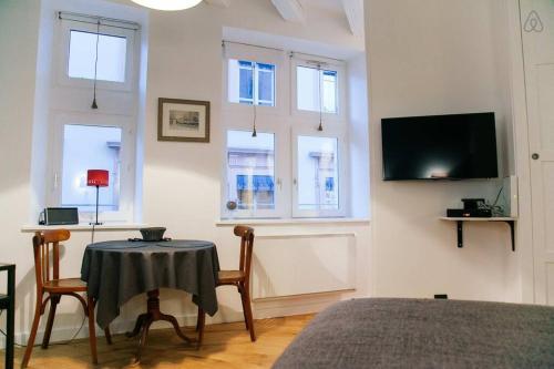 a bedroom with a table and a tv on a wall at Saint-Paul Vieux Lyon - parking included in Lyon