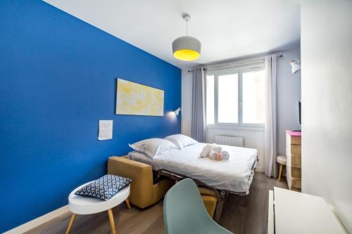 a small room with a bed and a blue wall at Appartement cosy, proche Part-Dieu AIL in Lyon