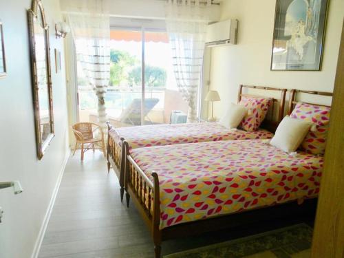 une chambre avec un lit dans une pièce avec une fenêtre dans l'établissement Havre de paix.Les Belles Terres.4 pers.Piscine, à Nice