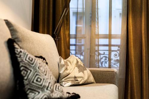 - un canapé avec des oreillers et une fenêtre dans la chambre dans l'établissement 70m2 de pur bonheur en plein centre - Rhône AIL, à Lyon