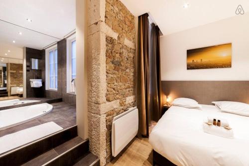 La salle de bains est pourvue d'un lit, d'une baignoire et d'un lavabo. dans l'établissement 70m2 de pur bonheur en plein centre - Rhône AIL, à Lyon